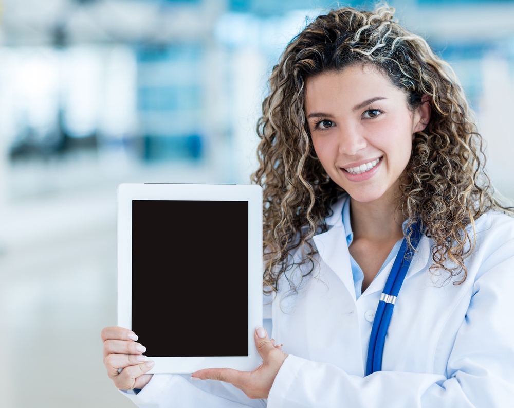 Female doctor holding a tablet computer and showing screen.jpeg