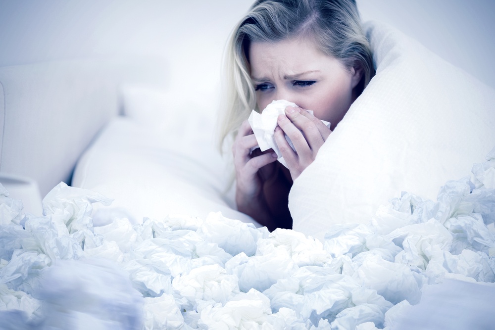 Blonde woman sneezing against used tissues.jpeg