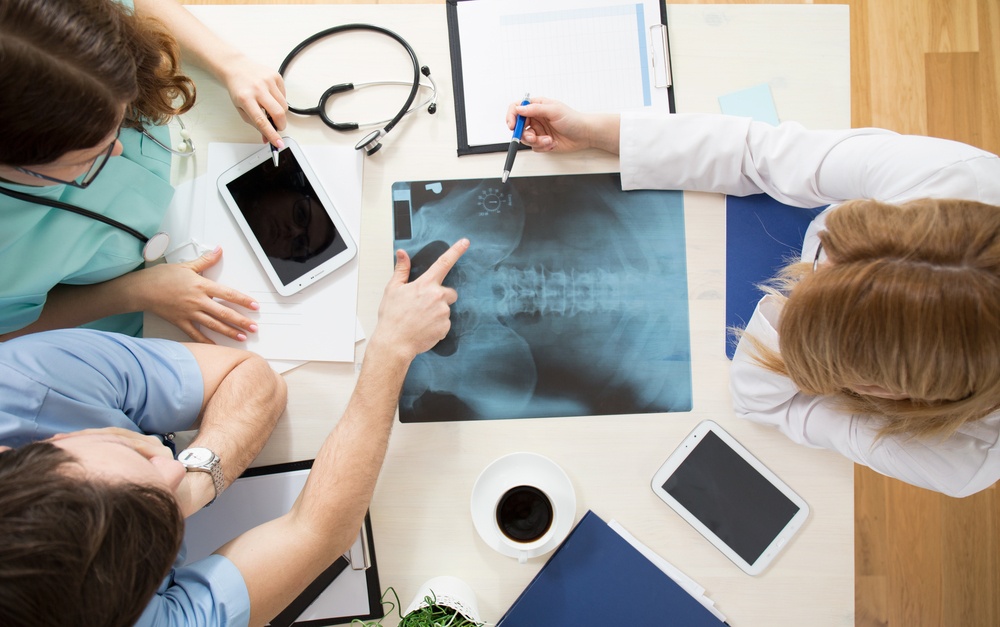 Doctors sitting around the table and interpreting x-ray image-2.jpeg